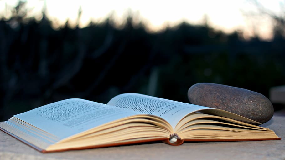 selective focus photo og opened book beside pebble, stone, lyrics HD wallpaper