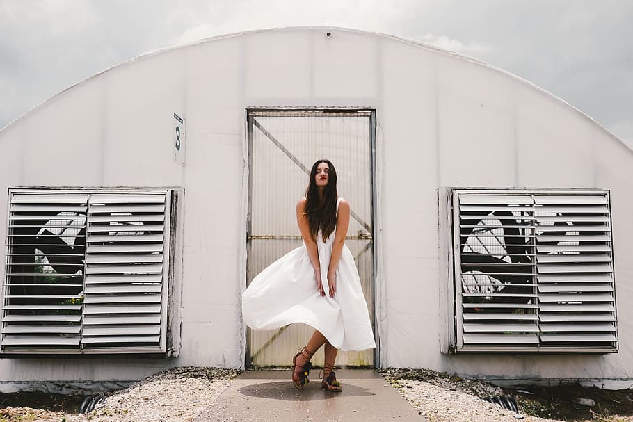 woman wearing white sleeveless dress standing in front of white painted door HD wallpaper