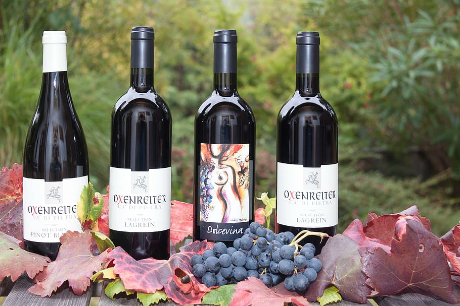 four wine bottles near grapes during daytime photography, label HD wallpaper
