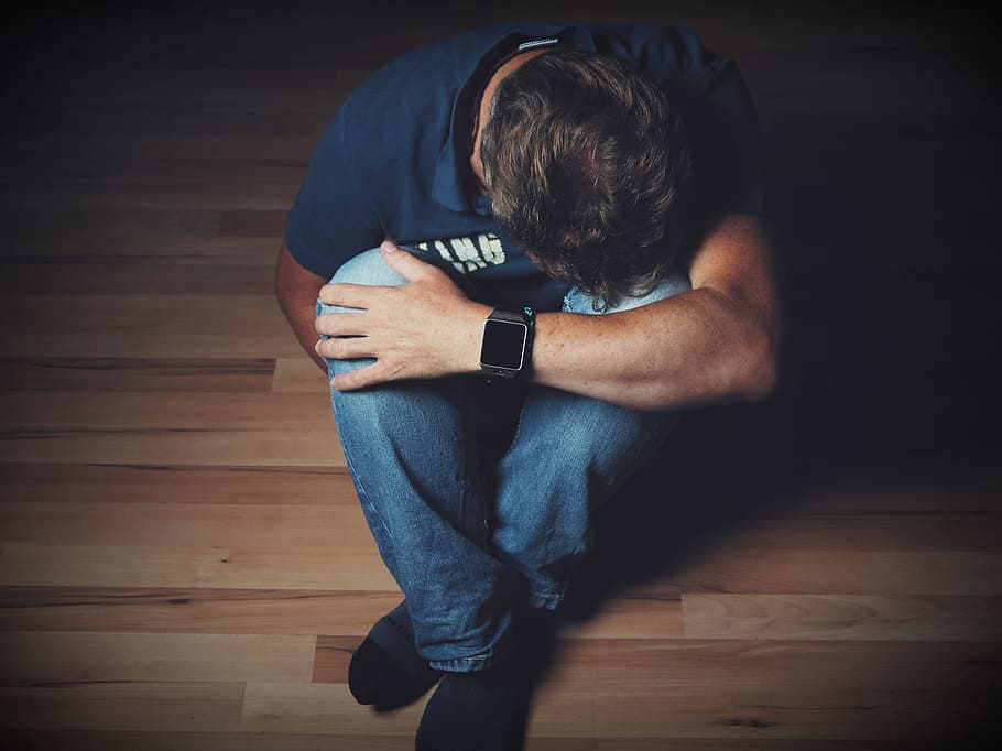 man wearing blue shirt and blue jeans, mourning, despair, emotion