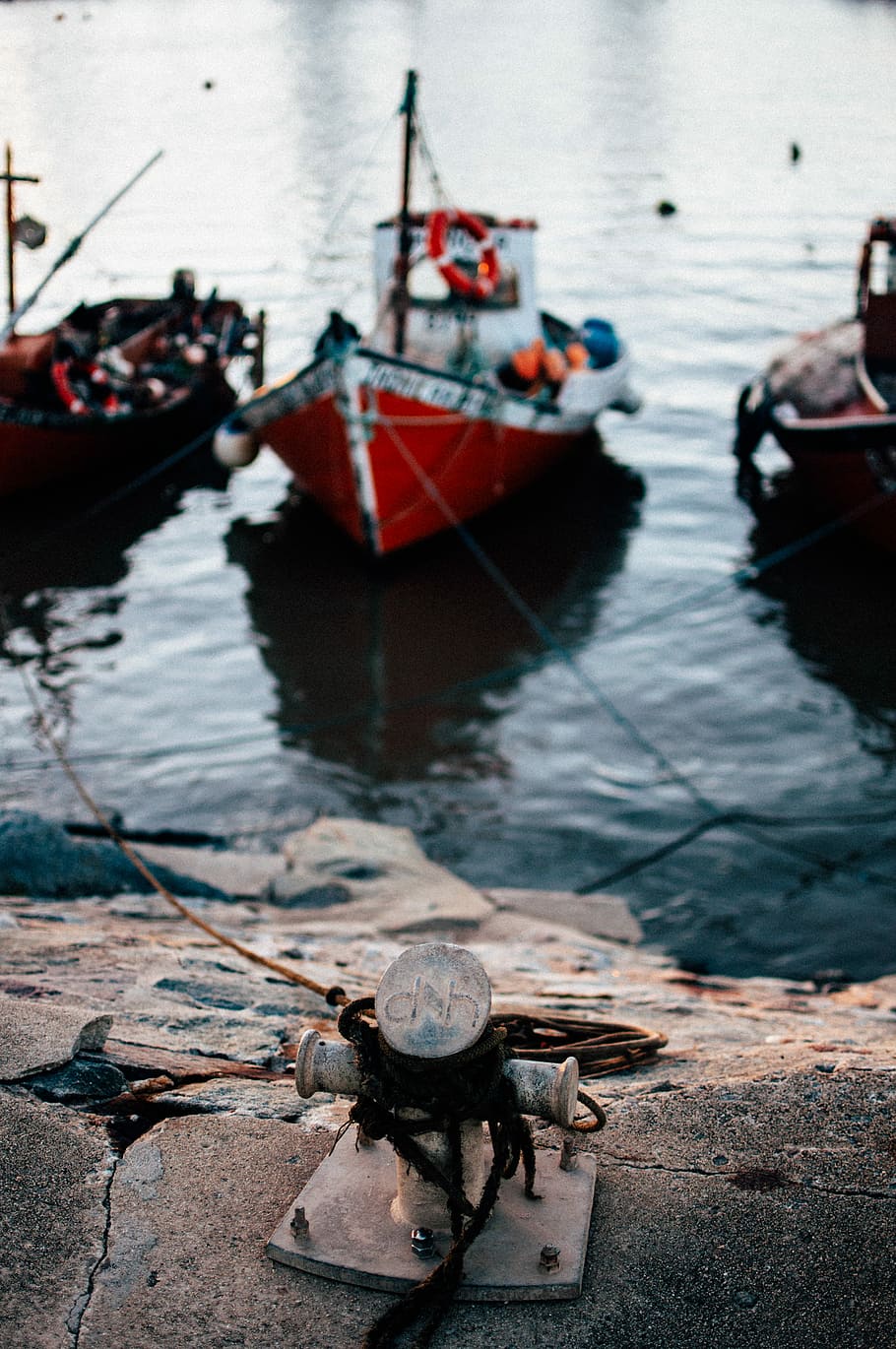 selective focus photo of three red boats on body of water view from gray pavement, red boats near dock during daytime HD wallpaper