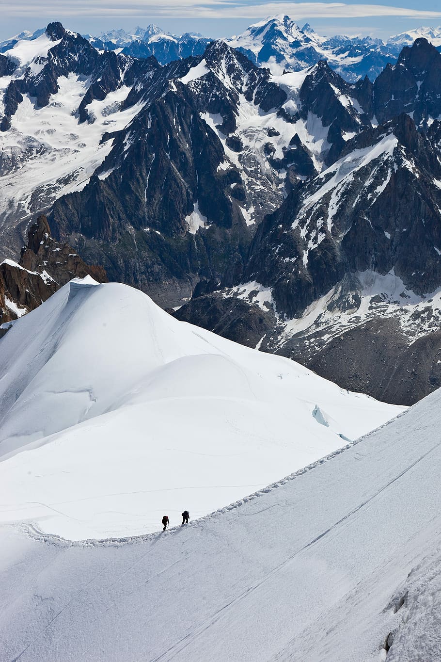 aerial view of two people hiking up snowy mountain, snow mountains during daytime HD wallpaper
