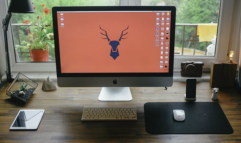 turned on silver iMac with keyboard and mouse beside white iPad HD wallpaper