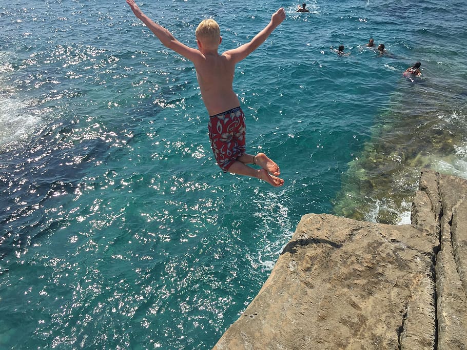 jumping boy on cliff during daytime, sea, greece, coast, rock HD wallpaper