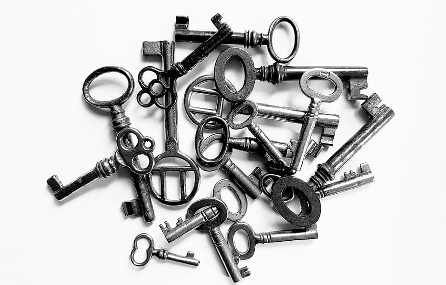 grayscale photo of pile of skeleton keys, close up, open, door key