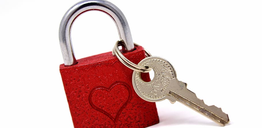 red and gray padlock and key on white surface, key to the heart