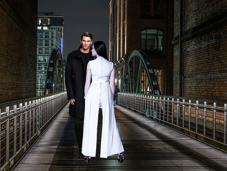 man standing on bridge with a woman in front of him, casal, night