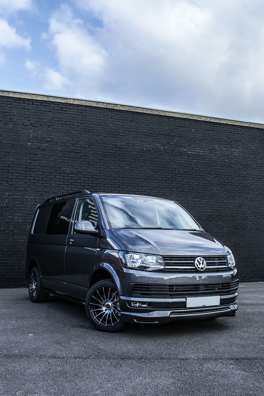 gray Volkswagen van parked behind black bricked wall under white cloudy skies at daytime, black Volkswagen van HD wallpaper