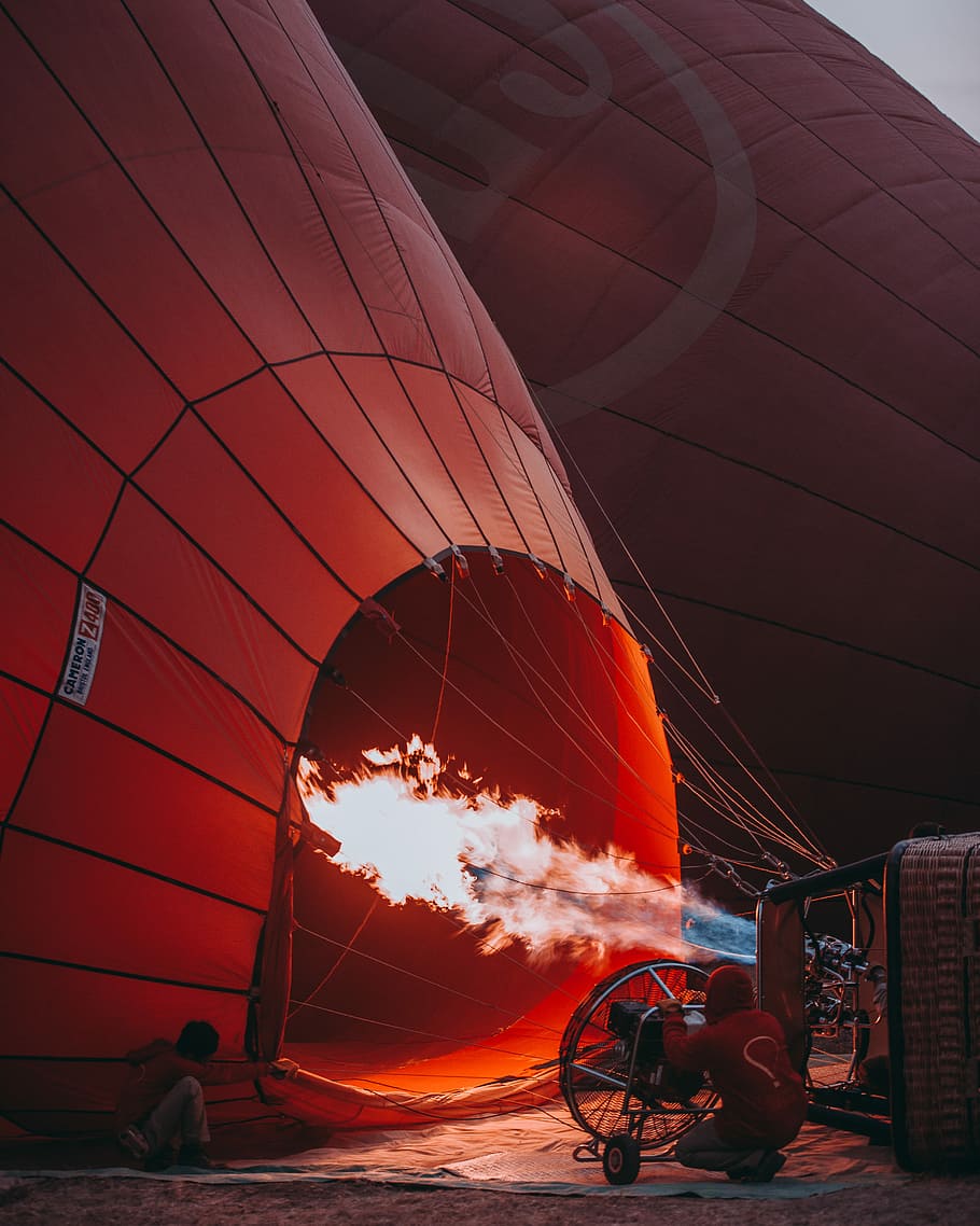 orange hot air balloon, red hot air balloon on floor, fire, prepare