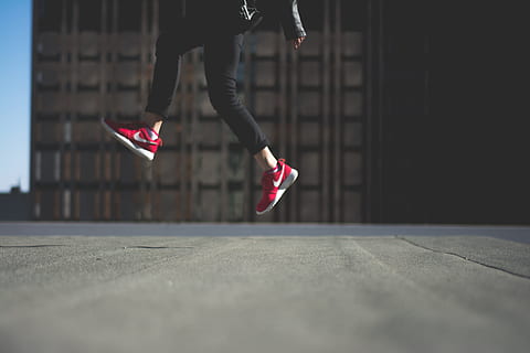 person wearing pair of red Nike shoes, photo of person jumping HD wallpaper