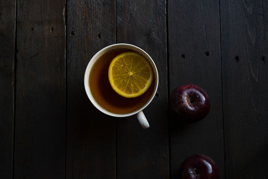 flat lay photography of white teacup, slice lemon on brown liquid HD wallpaper