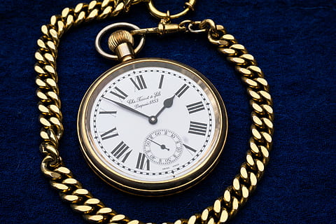 round white analog pocket watch with gold-colored frame on blue textile HD wallpaper