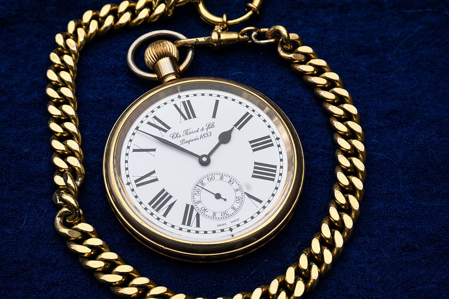 round white analog pocket watch with gold-colored frame on blue textile HD wallpaper