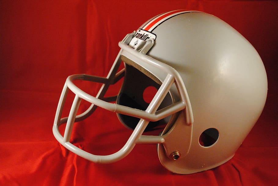 gray and red football helmet on red textile, sport, american