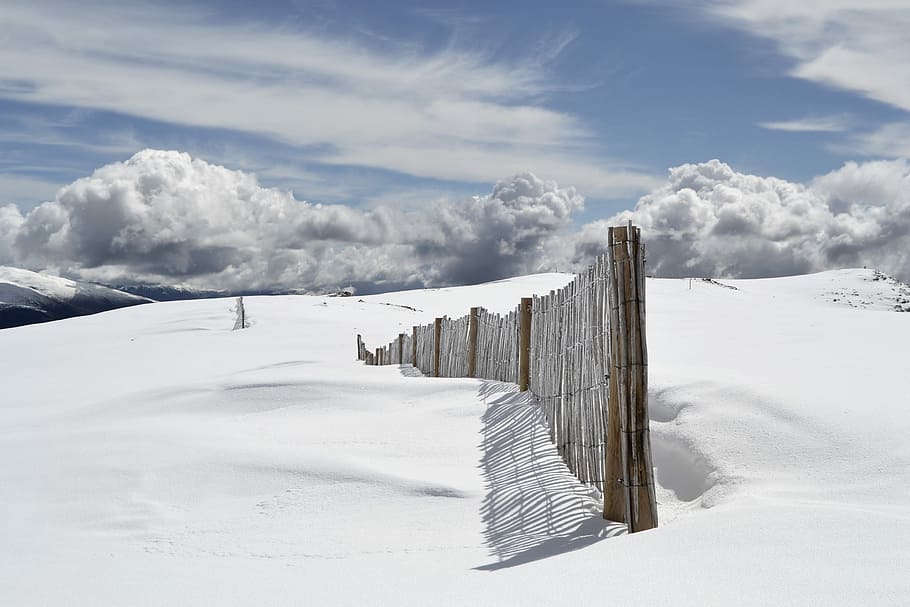 brown wooden fence on snow field under gray clouds, filed covered with snow HD wallpaper