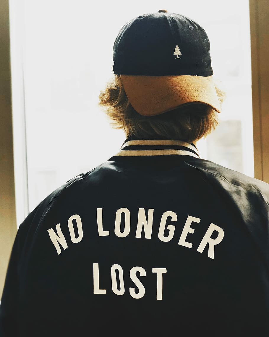 man wearing black letterman jacking facing window, man wearing black and white no longer lost-printed jacket HD wallpaper