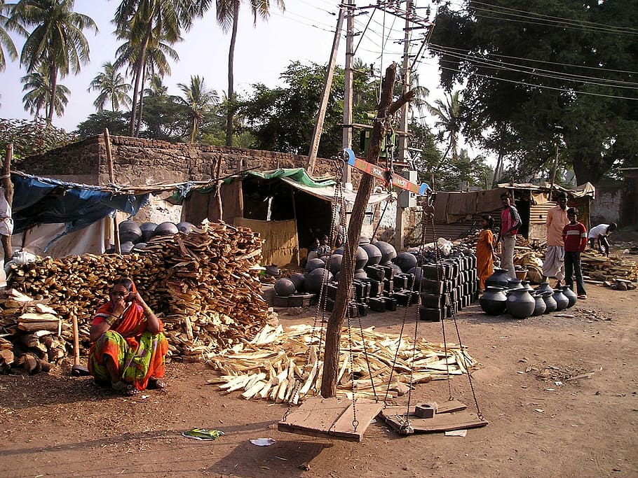 firewood and clay pot piled outside the house, india, poverty