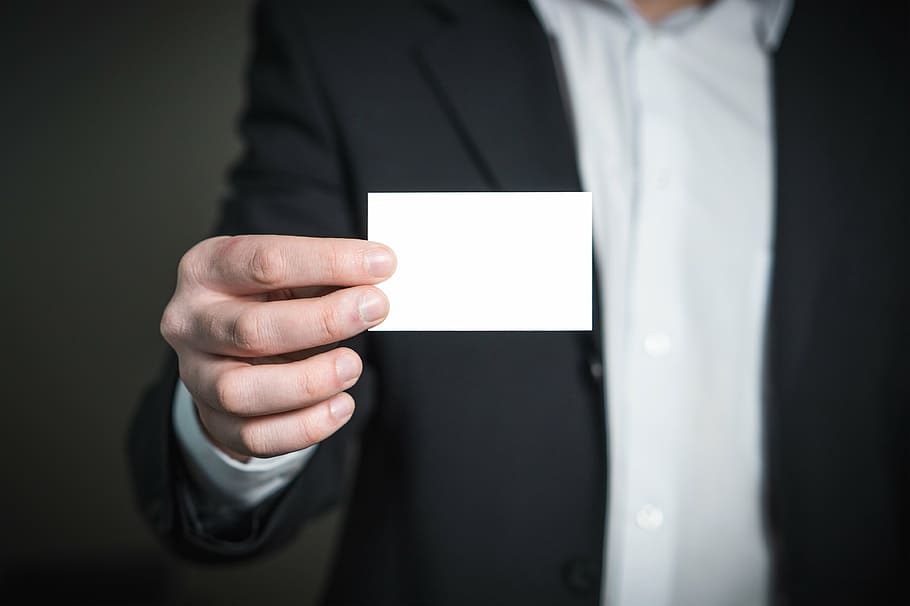 person holds white card, business card, man, holding, hand, suit