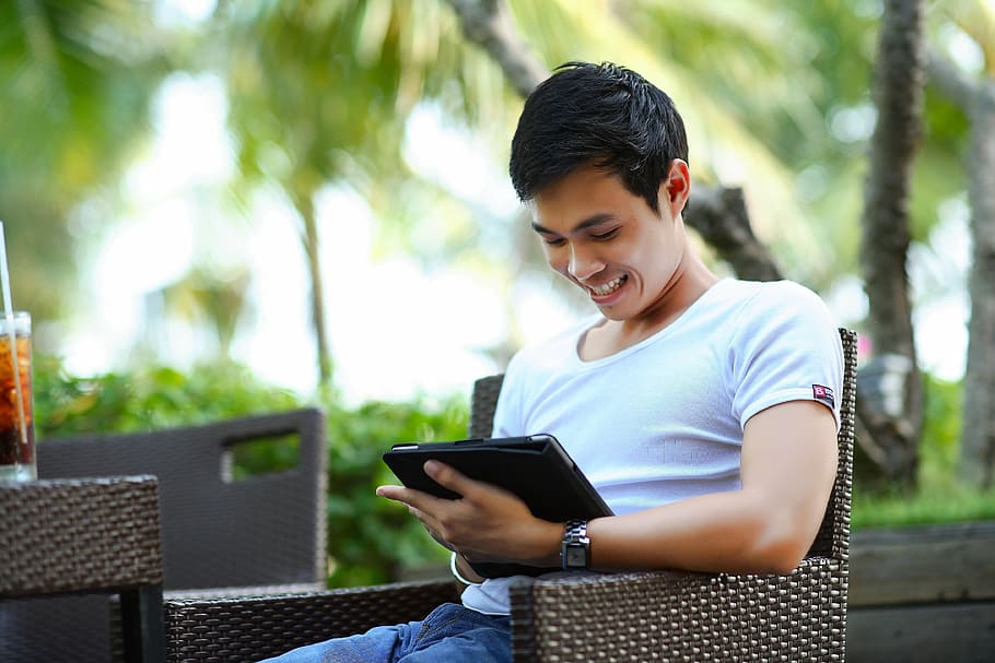 shallow focus photography of a man sitting on brown rattan armchair HD wallpaper