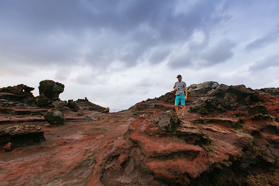 person standing on top on boulder, man standing near rocks, low angle HD wallpaper