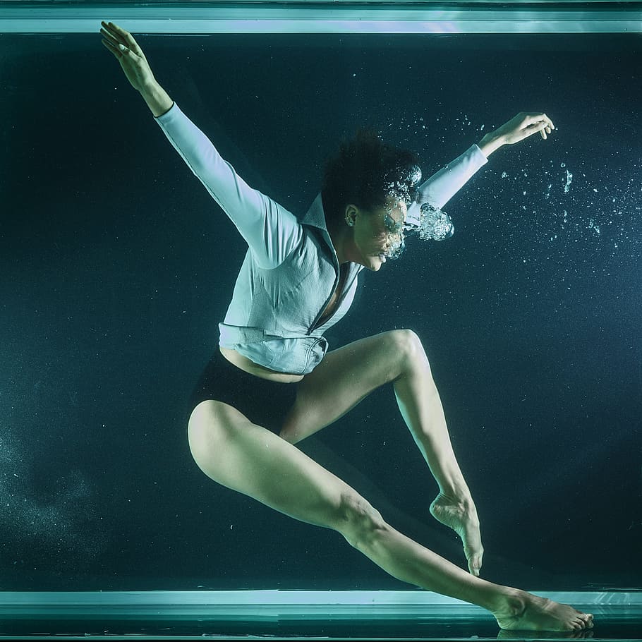 woman in white shirt and black panty in body of water, underwater