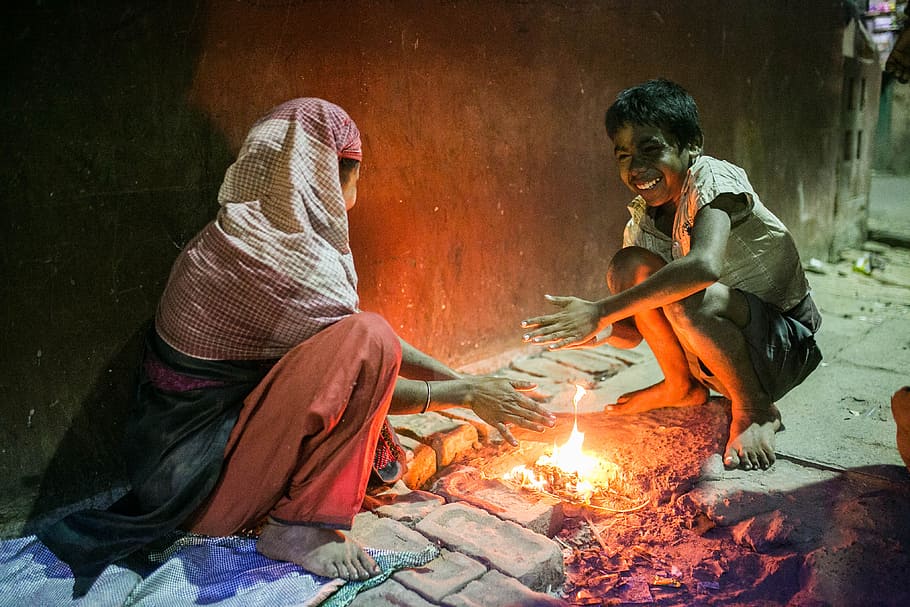 fire between woman and boy, woman and boy sitting in front of bonfire HD wallpaper