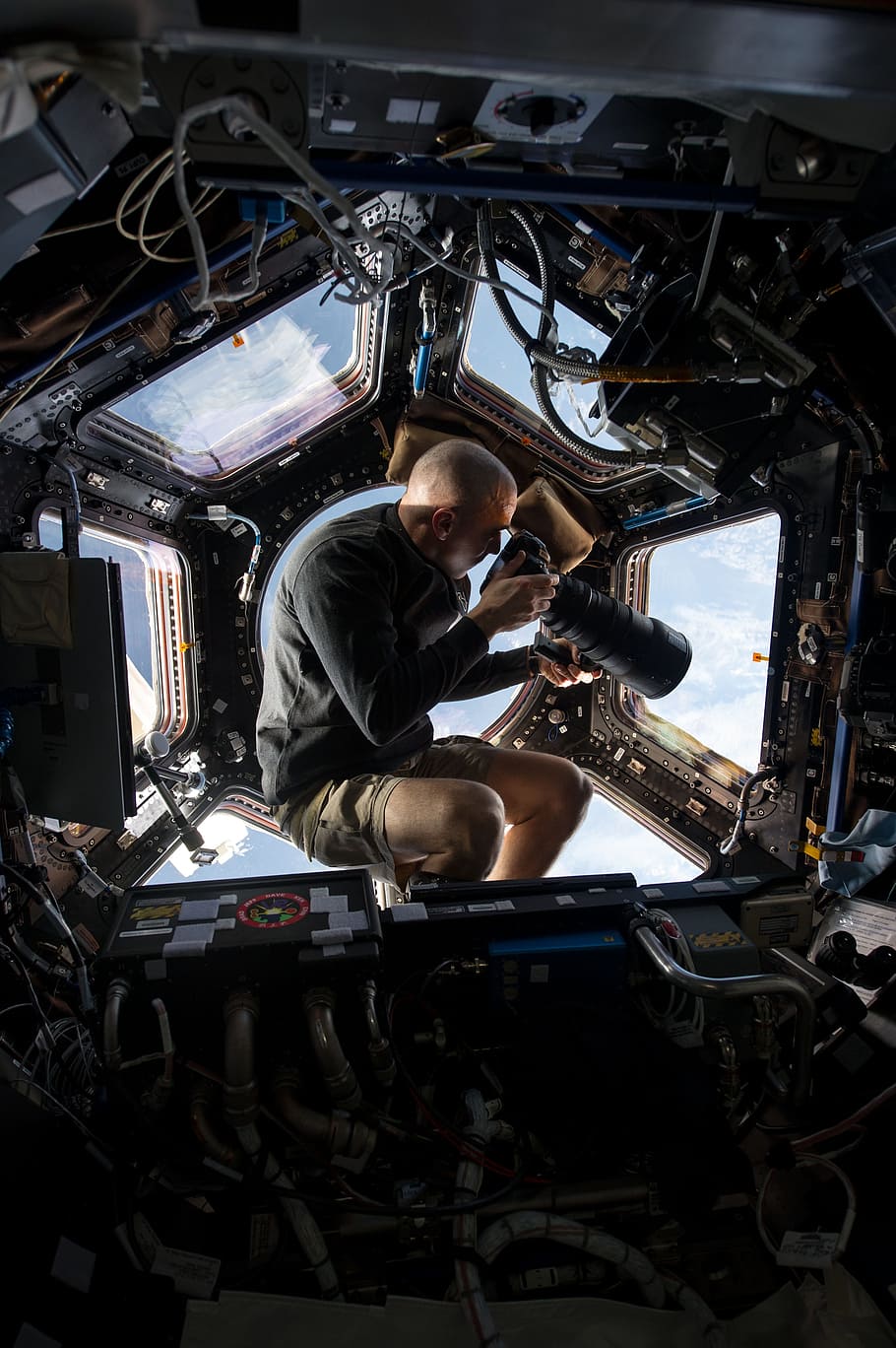 man holding DSLR camera, astronaut, space station, cupola, flight engineer HD wallpaper
