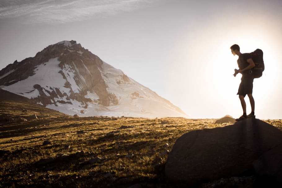 man carrying hiking backpack climbing mountain during day, snow HD wallpaper