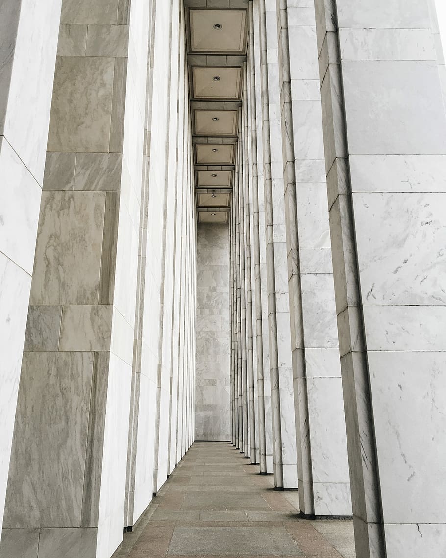 white concrete posts inside room, selective focus photography of white concrete tiled panel building pillars HD wallpaper
