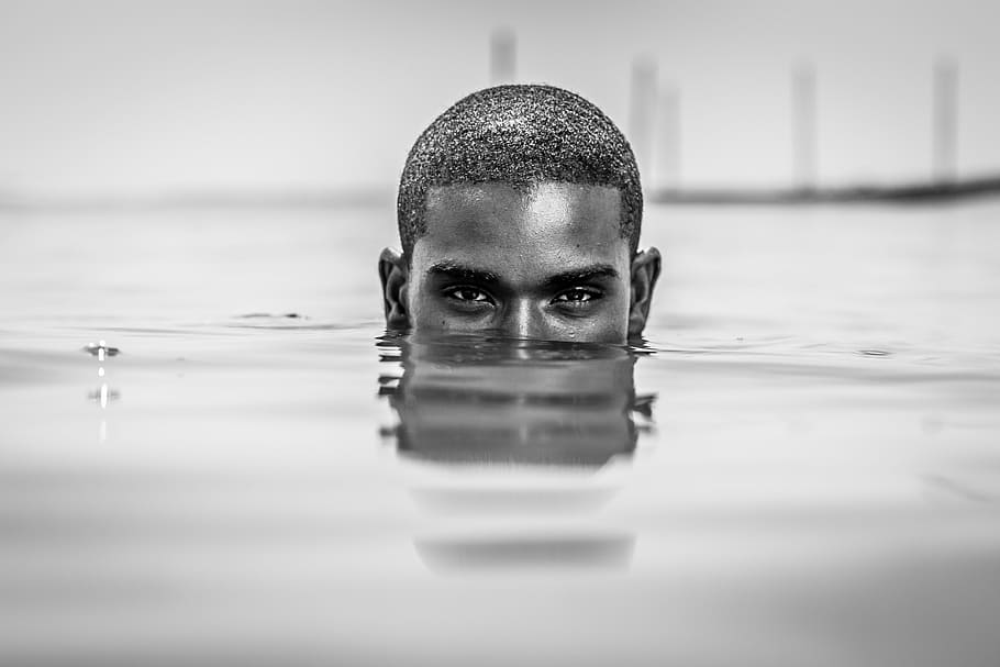 macro photography of half-face of man's head underwater, agua