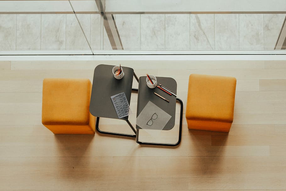 two orange ottoman chairs near gray side tables, two white ceramic mug on gray coffee tables HD wallpaper