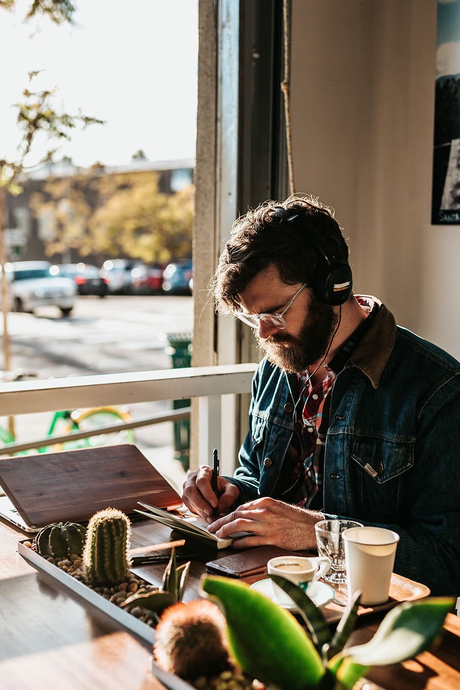 man sitting on table in front of table wriing on paper, man sitting white writing on notebook HD wallpaper