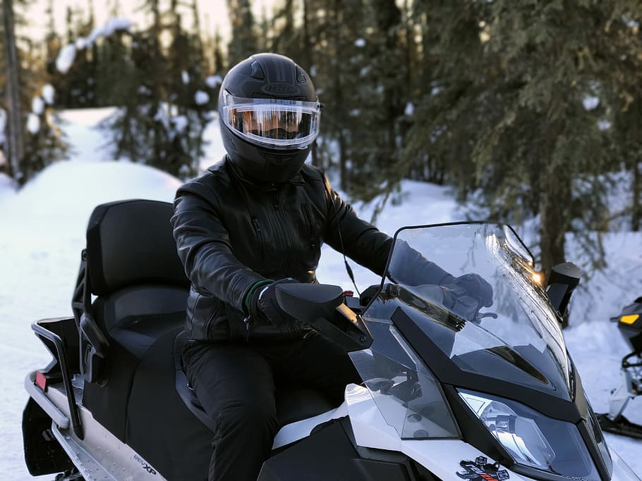snowmobile rider, man riding on black snow mobile, active, extreme