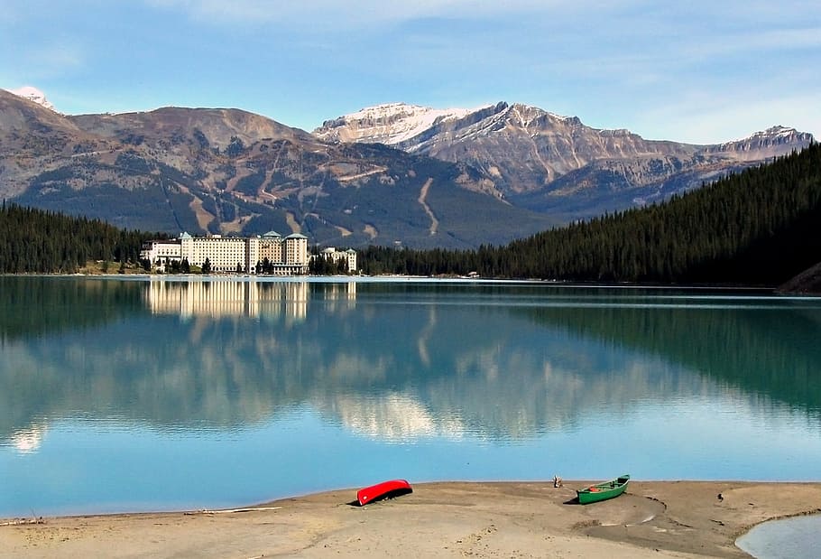 two red and green kayaks near calm body of water, lake louise