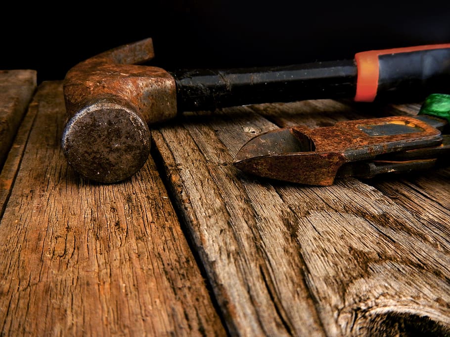 close-up photo of black claw hammer beside plier on brown wooden surface HD wallpaper