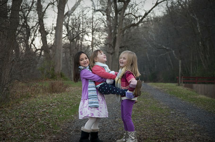 three girls playing near trees during daytime, sisters, holding HD wallpaper