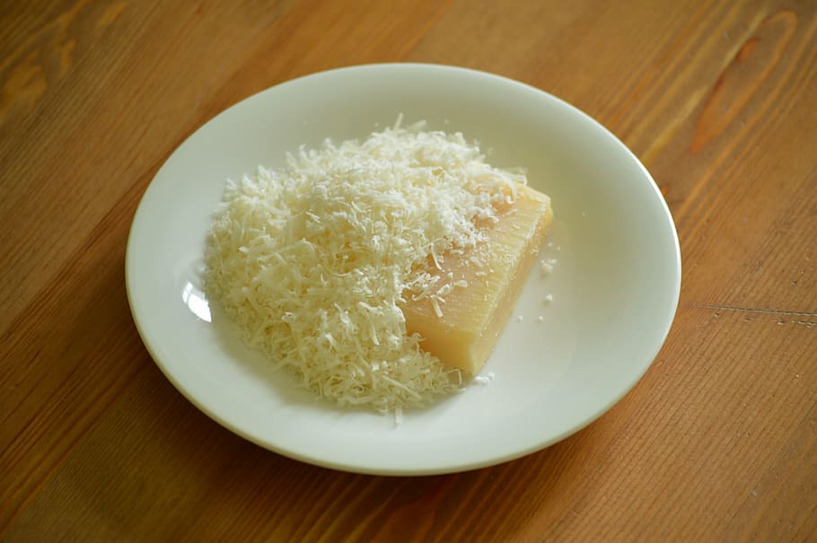 rice cake on round white plate, parmesan, cheese, grated, shredded