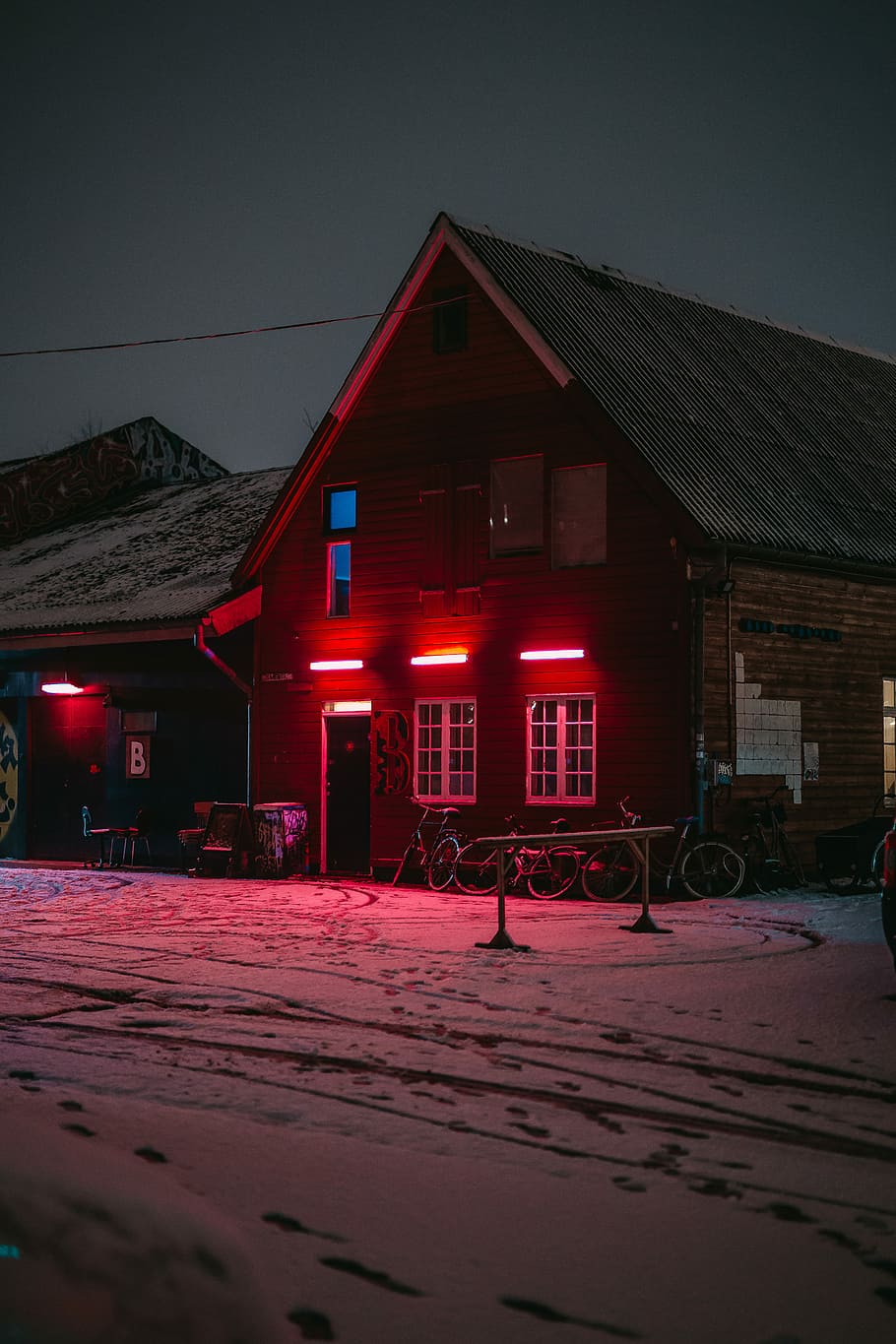brown house in icy land, bicycles in front of brown wooden house during night time HD wallpaper