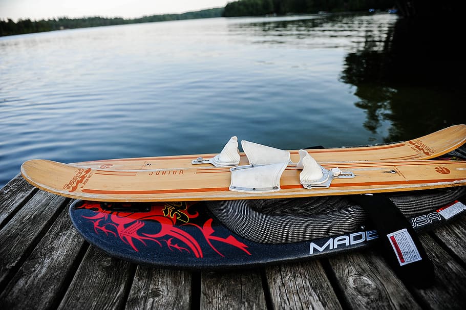 brown water ski on gray wooden dock near body of water, brown wooden snowboard on black dock, HD wallpaper
