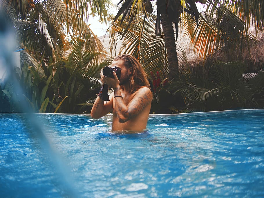 man holding camera in swimming pool, man holding camera on swimming pool HD wallpaper