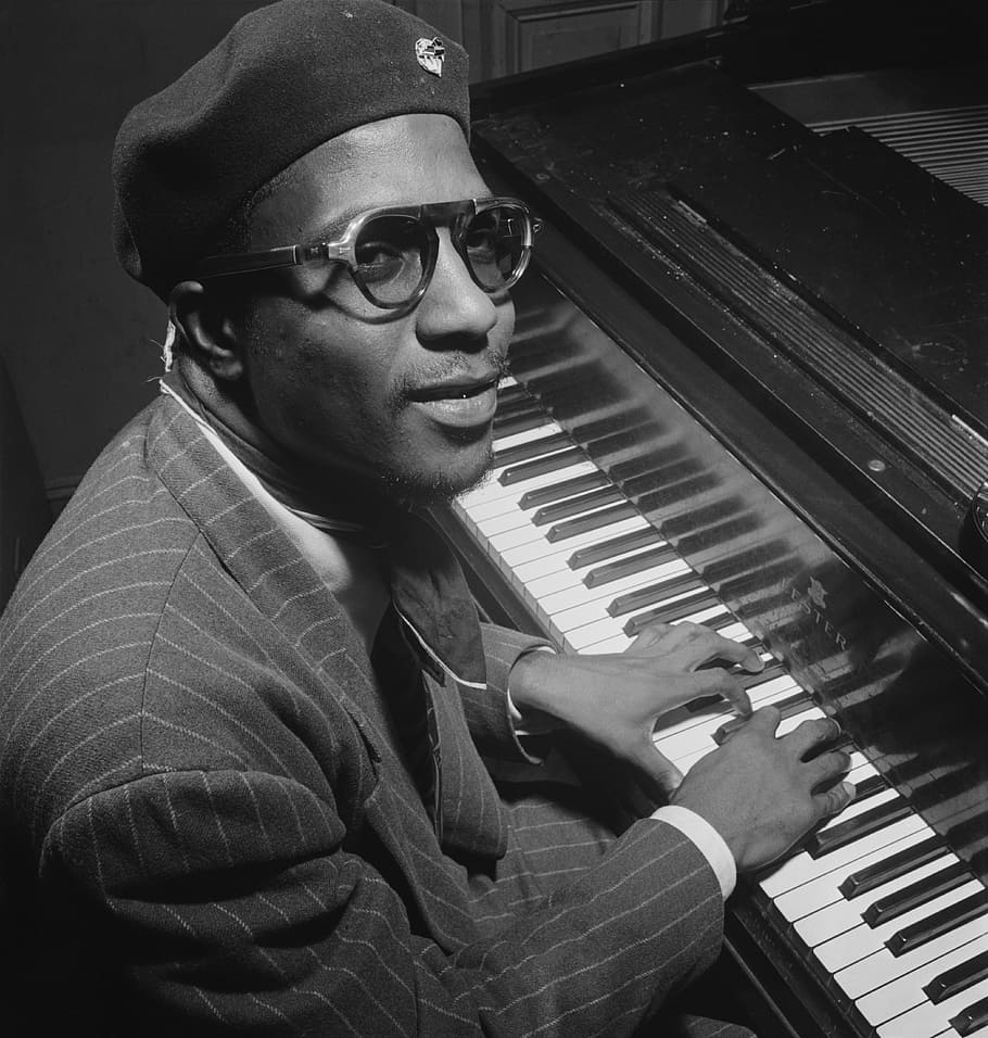 greyscale photo of man playing piano inside room, thelonious sphere monk