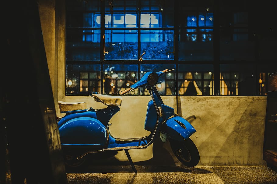 blue motor scooter parked beside gray cocnrete wall with glass windows during nighttime photo, blue motor scooter beside wall HD wallpaper
