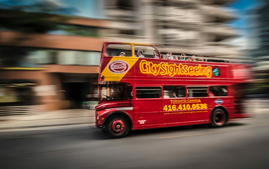 red and yellow bus photo, red double-decker bus passing by building HD wallpaper