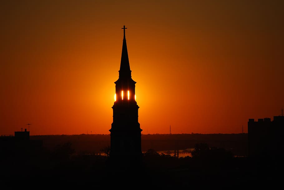 silhouette photograph of church's tower during golden hour, steeple