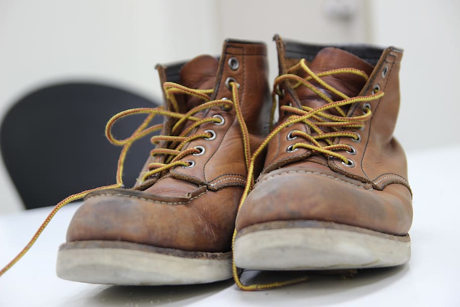 pair of brown leather lace-up shoes on white panel board in selective focus photography HD wallpaper