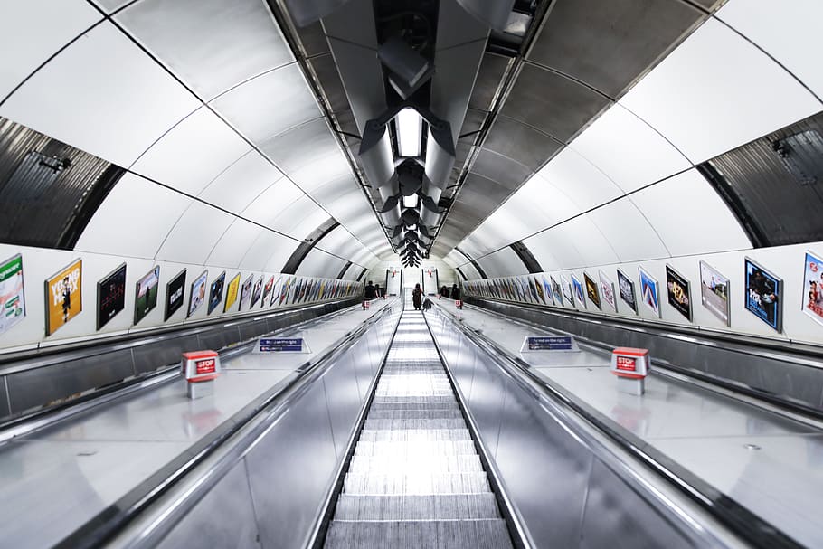 escalator in middle of black handrails, Entering the London Underground
