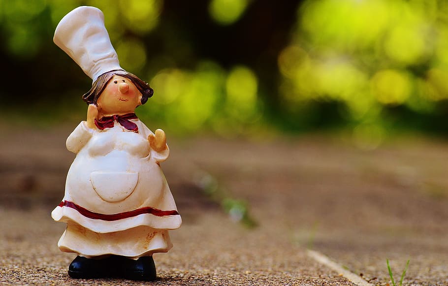 selective focus photography of female chef figurine on surface