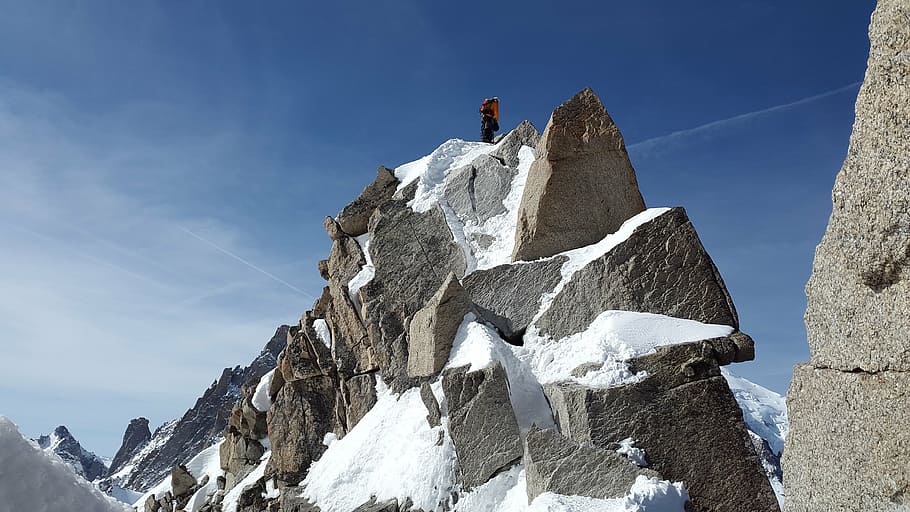 person standing on black monolith covered with snow, cosmiques ridge HD wallpaper