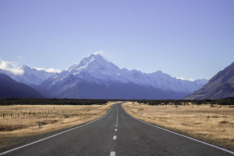 landscape photography of empty dessert road under blue calm sky with mountain view, black asphalt road with view of mountains