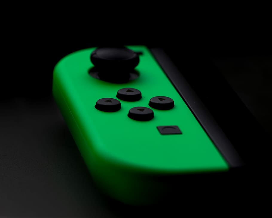close-up photography of Nintendo Switch neon green controller, Nintendo Switch gamepad on black top